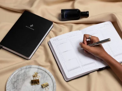 Persoon schrijft creatieve ideeën en plannen in een notitieboek